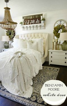 a white bed sitting in a bedroom next to a chandelier