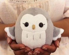 a person holding a stuffed owl in their hands