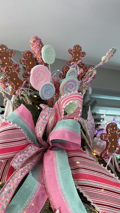 a christmas tree decorated with pink, blue and green ribboned candy canes in the shape of trees