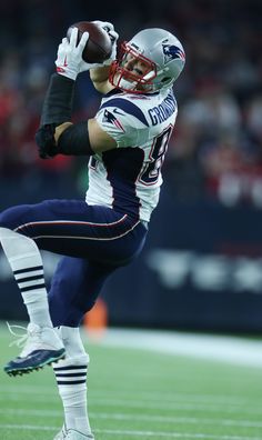 a football player in mid air catching a ball