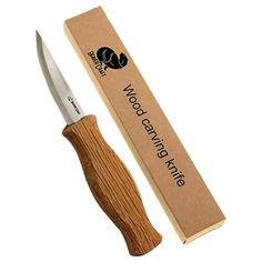 the knife is in its box and next to it's cardboard package with wood handle