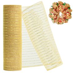 two rolls of gold mesh next to a wreath and christmas decorations on a white background