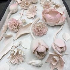 there are many pink flowers on the table and one is made out of fondant