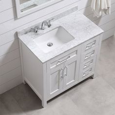 a white bathroom sink sitting under a mirror