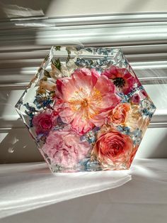 a vase filled with flowers sitting on top of a white table next to a window