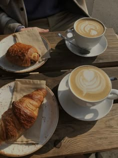 two plates with croissants and coffee on them