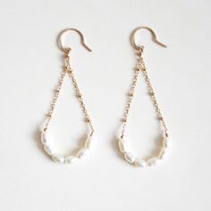 Freshwater pearl arch dangle earrings handmade with hypoallergenic 14k gold-filled wire that is nickel-free. Freshwater pearls are cultivated in freshwater environments like lakes and rivers. Their thick nacre coating makes them durable and relatively sweat-resistant, ideal for daily wear. These elegant earrings are suitable for both everyday and special occasions! Each piece is handcrafted, so slight variations in shape may occur. These earrings will be made for you after the order is placed. MATERIALS14k gold filled wireFreshwater pearlsRubber Ear nuts DIMENSIONSapprox. 7/8" (24mm) width x 2 1/4" (58mm) length 14k Gold-filled Teardrop Pearl Chain Jewelry, 14k Gold Filled Pearl White Dangle Pearl Earrings, White Long Drop Pearl Earrings In 14k Gold, Teardrop 14k Gold Filled Pearl Chain Jewelry, Teardrop Pearl Chain Jewelry In 14k Gold Filled, White Long Drop Pearl Earrings In 14k Gold Filled, Teardrop Pearl Charm Earrings In 14k Gold, 14k Gold-filled Pearl White Dangle Pearl Earrings, 14k Gold Filled Pearl Drop Jewelry