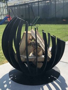 a fire pit made out of metal and wood sitting on top of a cement slab