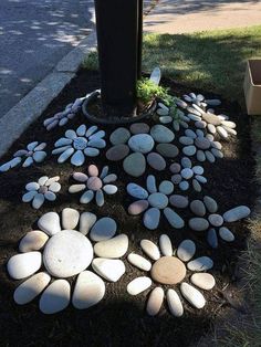 a bunch of rocks that are sitting in the grass next to a mailbox and tree