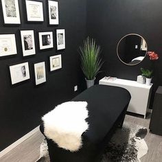 a black and white room with pictures on the wall, a bench and a mirror