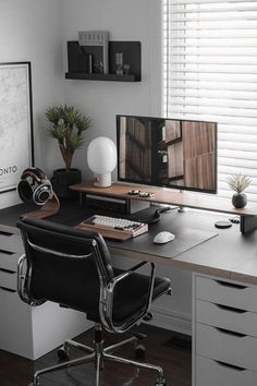 a desk with a computer monitor, keyboard and headphones sitting on top of it