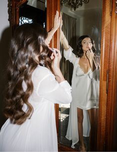 a woman brushing her teeth in front of a mirror