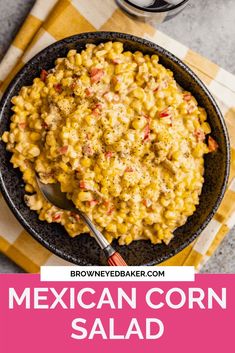 mexican corn salad in a black bowl on a yellow and white checkered napkin