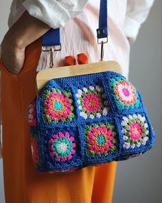 a woman holding a crocheted purse in her hands