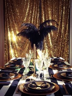 a table set with black and gold place settings