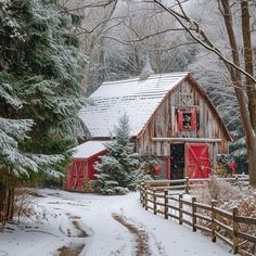 a red barn sits in the middle of a snowy forest