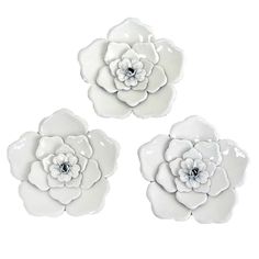 three white ceramic flowers on a white background