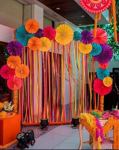 there are many colorful paper umbrellas hanging from the ceiling and decorations on the wall