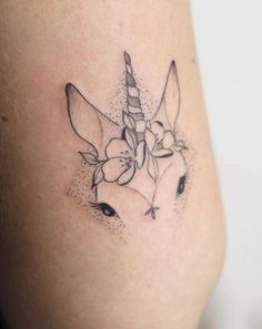 a small tattoo of a unicorn with flowers on it's back side thigh,