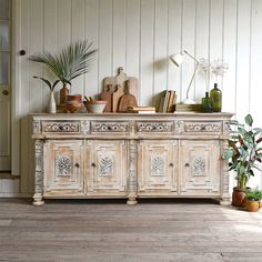 an old dresser with plants and books on top