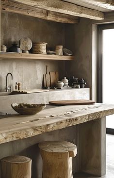 a kitchen counter with bowls, plates and cups on it's shelf next to two stools