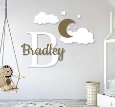 a child's bedroom with a teddy bear on a swing and the name bradley above it