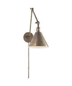 an old fashioned wall light with a metal shade on the arm and a white background