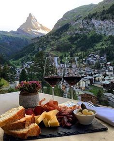 a table topped with bread and cheese next to a glass of wine