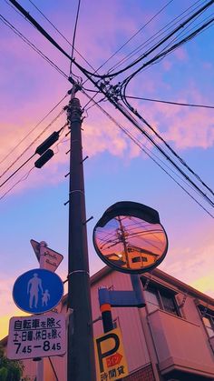 a pole that has some signs on it and a building in the backround