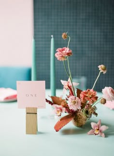 a table with a sign that says one on it and some flowers in the middle