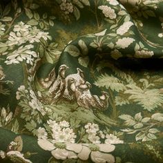 the fabric is green with white flowers and leaves