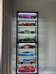 a display case filled with lots of different colored toy cars in front of a window