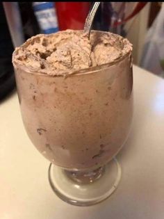 a glass filled with ice cream sitting on top of a table