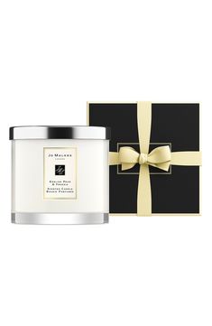 a candle and gift box with a bow on the lid, both in black and white