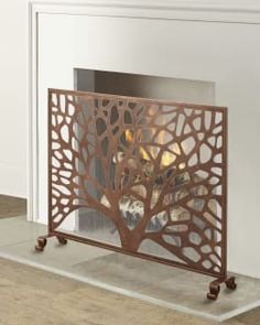 a fire place with a metal screen on the front and back sides, in an empty room