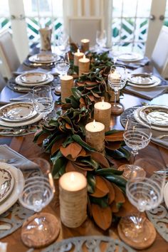 the table is set with candles, plates and place settings for dinner guests to enjoy