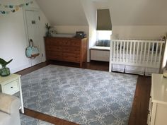 a baby's room with a crib, dresser and bed in the corner