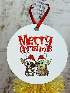 a christmas ornament hanging from a tree with a dog and baby yoda on it