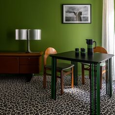 a dining room with green walls and leopard print flooring on the carpeted floor