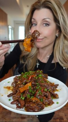 a woman eating food with chopsticks in her mouth