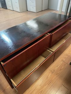 a large wooden cabinet with two drawers on the bottom and one drawer open in front of it