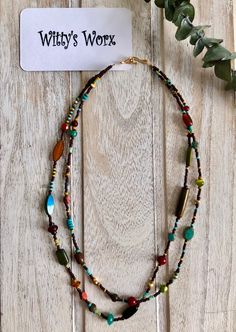 Handmade multi colored beaded necklace, features two strands 18 and 19 inches long.  Beads include Picasso glass beads, wood beads, bone beads, coral beads, seed beads, Tigereye beads and gold filled beads, in shades of brown, yellow, turquoise, red, blue, green and black.  The necklace is finished with a gold toned hook and eye. Please note, colors may vary slightly in person as all computer monitors display colors slightly different. Multicolor Double Strand Beaded Necklace With Large Beads, Multicolor Double Strand Necklace With Large Beads, Multi-strand Heishi Beaded Necklaces, Multi-strand Beaded Heishi Necklaces, Brown Multi-strand Necklace With Colorful Beads, Beach Double Strand Beaded Necklaces With Colorful Beads, Earthy Style Large Multicolor Beads, Multi-strand Wooden Beaded Necklaces For Beach, Double Strand Beaded Necklaces For Beach