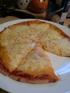 a cheese pizza on a white plate with one slice missing from the rest of it