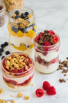 three jars filled with granola, yogurt and berries