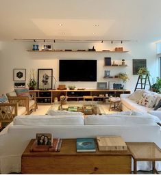 a living room filled with furniture and a flat screen tv mounted to the side of a wall