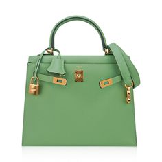 Guaranteed authentic Hermes Kelly Sellier 25 bag featured in fresh Vert Criquet. Stunning Hermes light green that is absolutely neutral. Luxurious with gold hardware.Epsom leather accentuates colours beautifully as it saturates to perfection. Comes with signature Hermes box, raincoat, shoulder strap, sleepers, lock, keys and clochette. NEW or NEVER WORN.The Hermes Kelly Sellier 25 cm bag price retains its value due to the rarity and high demand. As a purveyor of exceptional and unique Hermes lux Luxury Green Tote Satchel, Luxury Green Office Bags, Luxury Green Satchel With Double Handle, Luxury Green Bags With Lock, Luxury Green Bag With Lock, Designer Green Satchel With Branded Hardware, Green Elegant Satchel With Branded Hardware, Elegant Green Satchel With Branded Hardware, Luxury Green Satchel With Handles