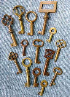 there are many different types of keys on the blue jeans background and one is gold