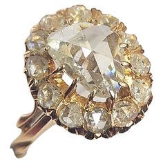 an old cut diamond ring is shown in yellow gold and white diamonds are surrounding it