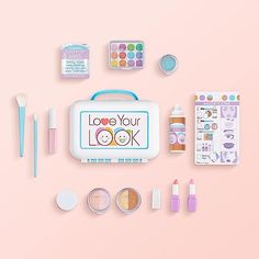 the contents of a children's makeup kit laid out on a pink background with pastel colors