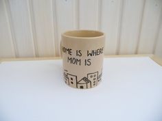 a ceramic cup that says home is where mom is